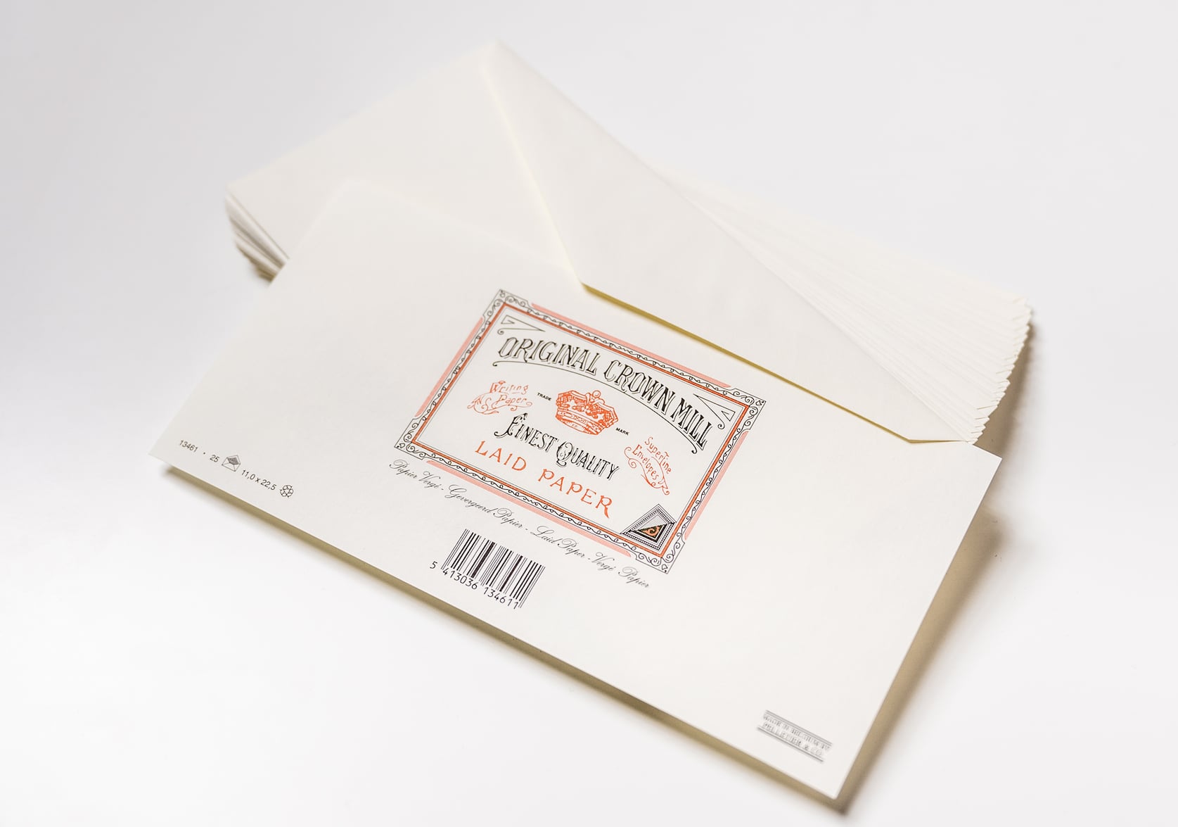 Stack of cream laid envelopes for A4 Notepad. In the centre there is a stamped red & black logo with a red brown. Text that reads: Original Crown Mill. Finest Quality. Laid Paper. Below there is a black barcode.