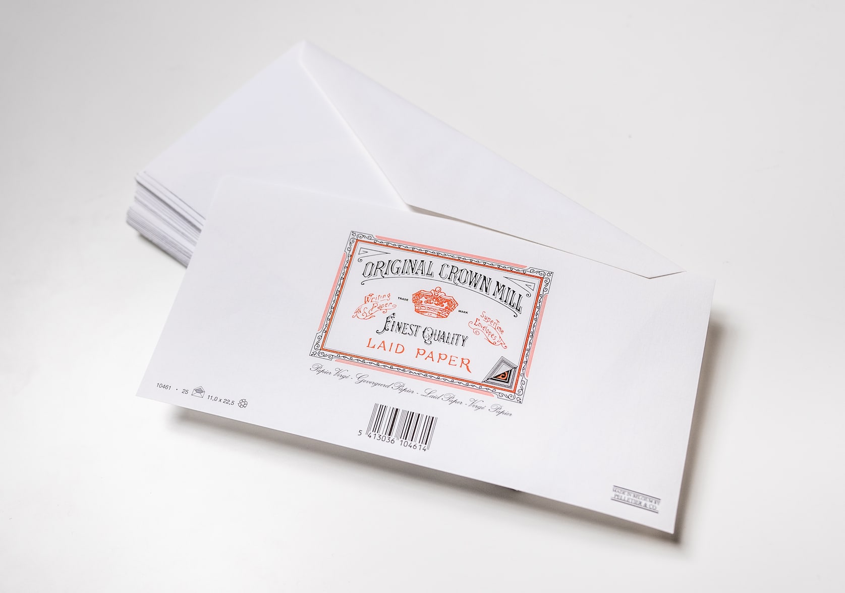 Stack of white laid envelopes for A4 Notepad. In the centre there is a stamped red & black logo with a red brown. Text that reads: Original Crown Mill. Finest Quality. Laid Paper. Below there is a black barcode.