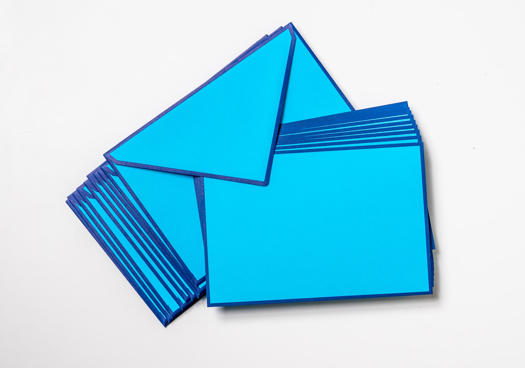 Arranged stack of Arctic Flat Note Cards and matching envelopes with navy blue border