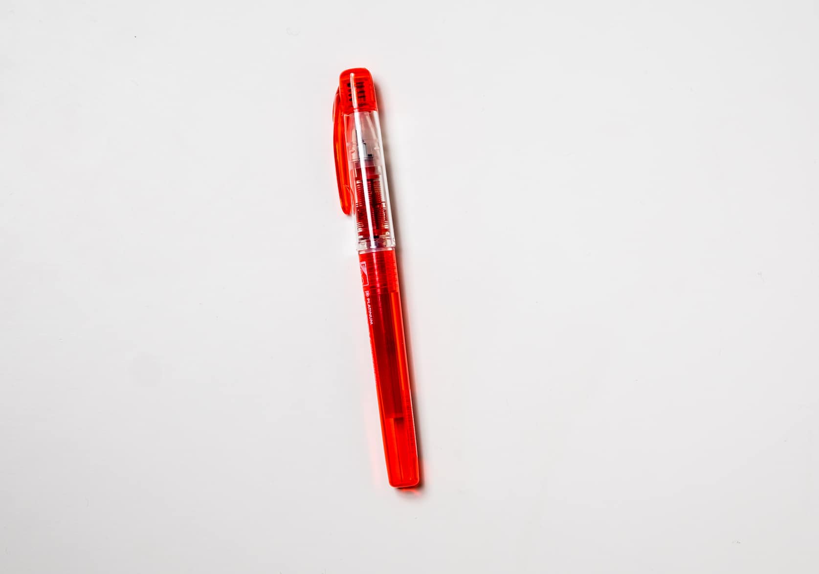 Fountain pen with a red barrel and pen clip.