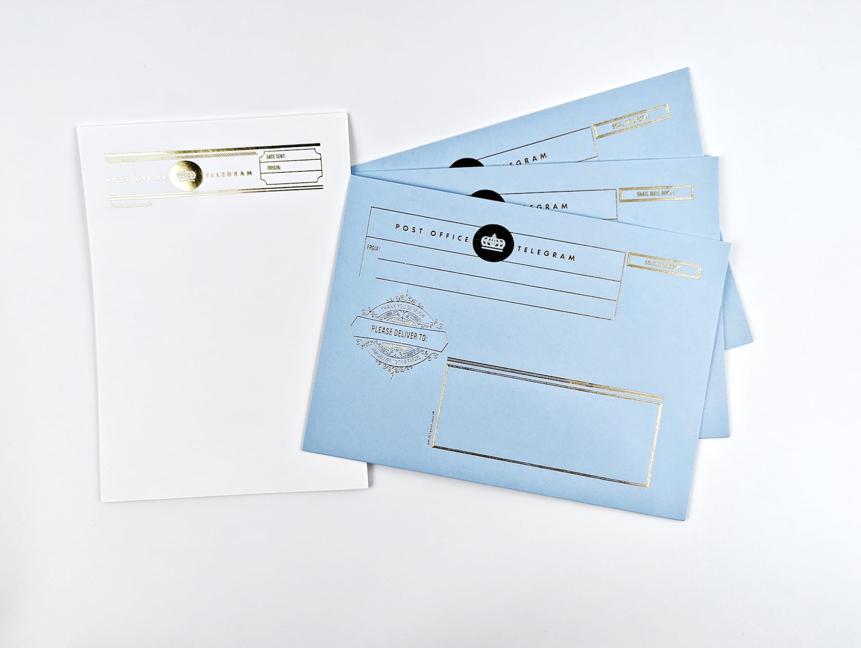 Three baby blue gold foiled envelopes featuring a gold crown, fake postage and text reads: Post Office Telegram. Please Deliver To. Includes white gold foiled letter writing paper in a retro telegram design.