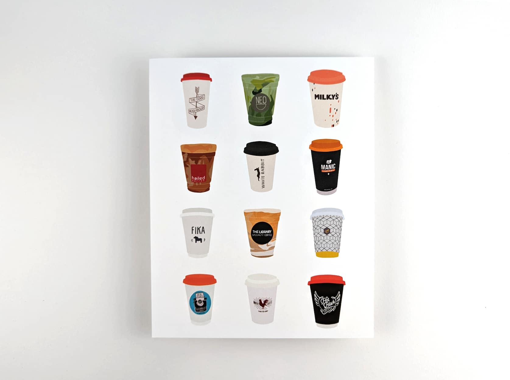 Print featuring illustrations of twelve coffee to-go cups from Toronto cafés against a white background. The twelve coffee cups are arranged in 4 rows with 3 cups in each row.
