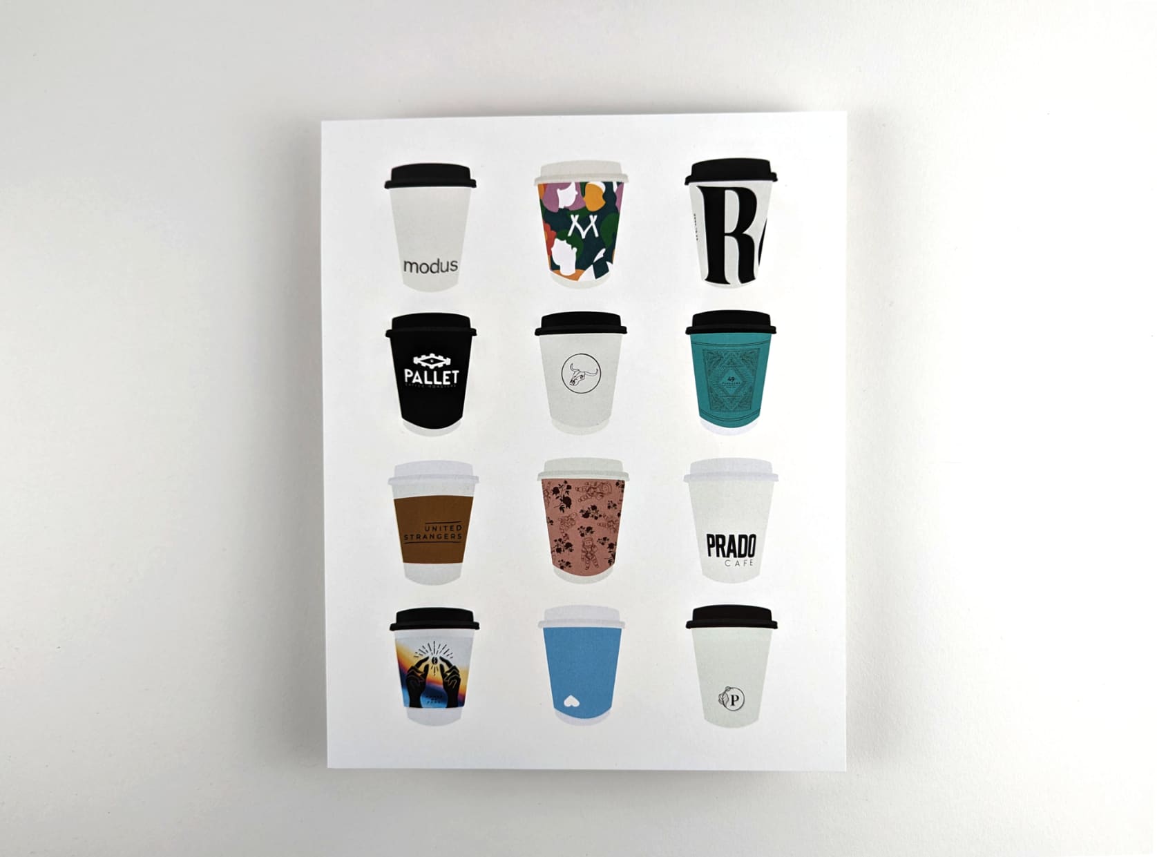 Print featuring illustrations of twelve coffee to-go cups from Vancouver cafés against a white background. The twelve coffee cups are arranged in 4 rows with 3 cups in each row.