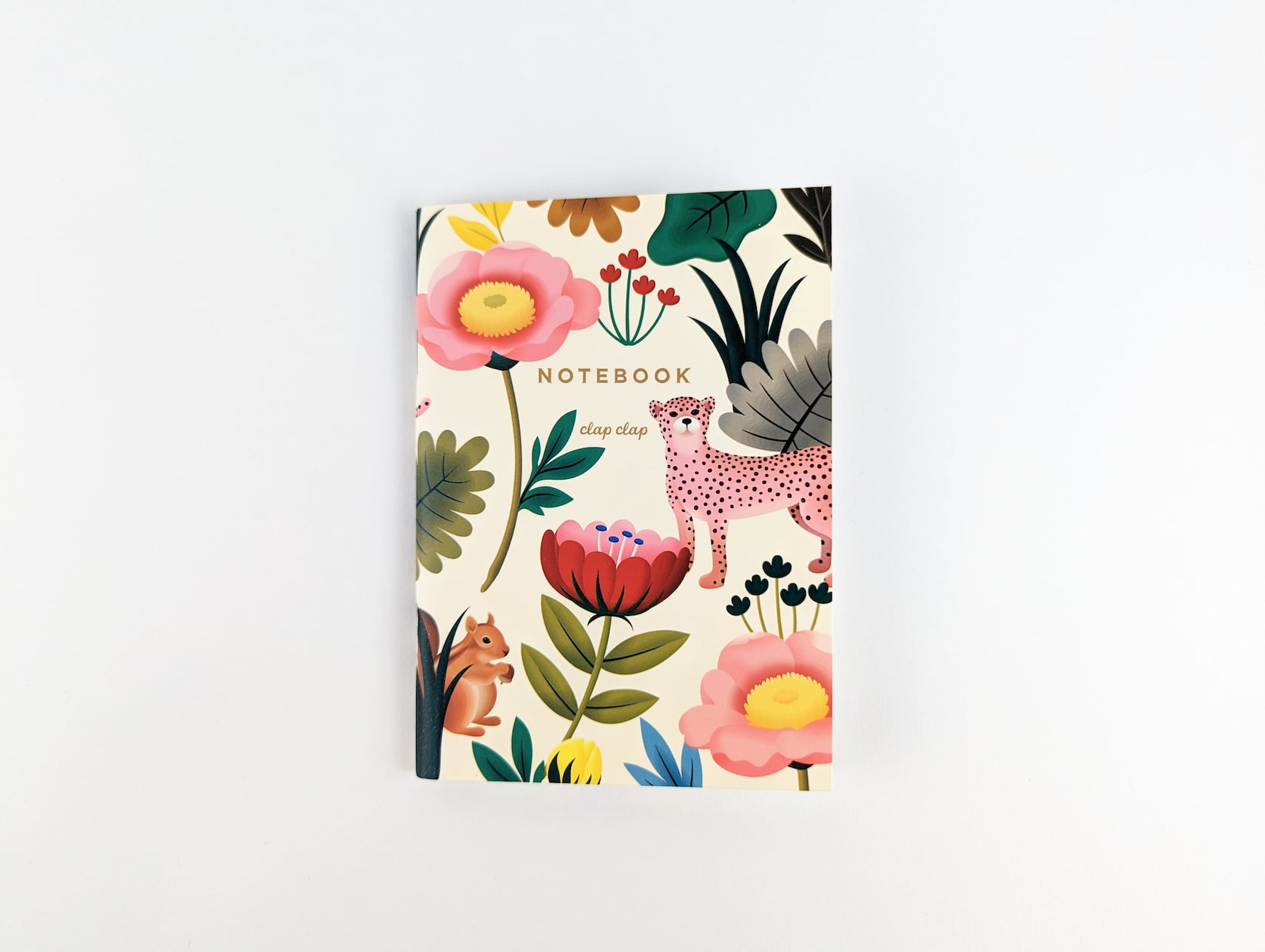 Cream notebook with gold text that reads: NOTEBOOK clap clap. A squirrel, a cheetah and a variety of multi-coloured flowers and leafs are featured around the text.