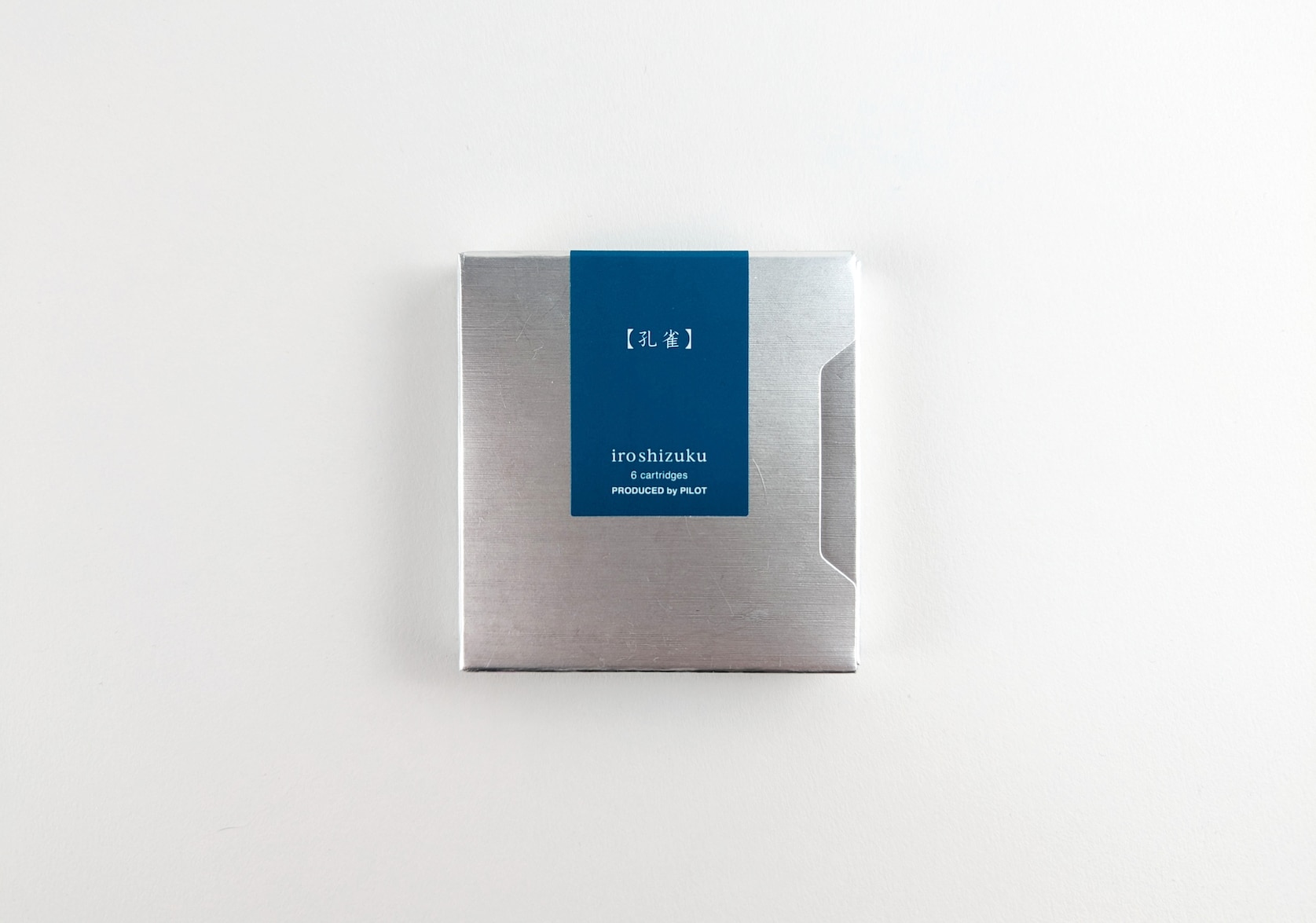 Silver sliding box. Rectangular turquoise sticker with white text that reads: ku-jaku. iroshizuku. 6 cartridges. Produced by Pilot.