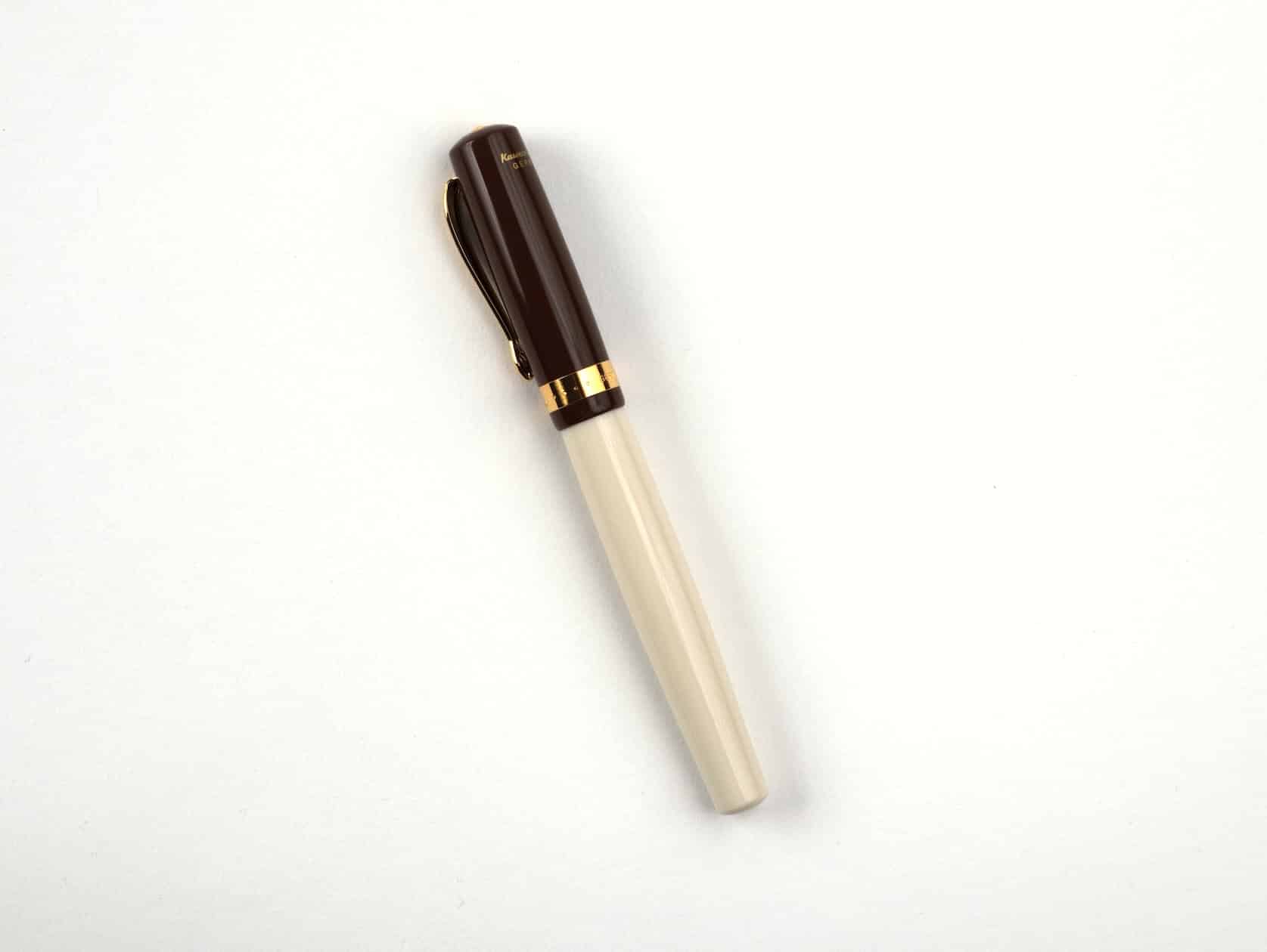 A cream fountain pen with a brown cap and golden accents.