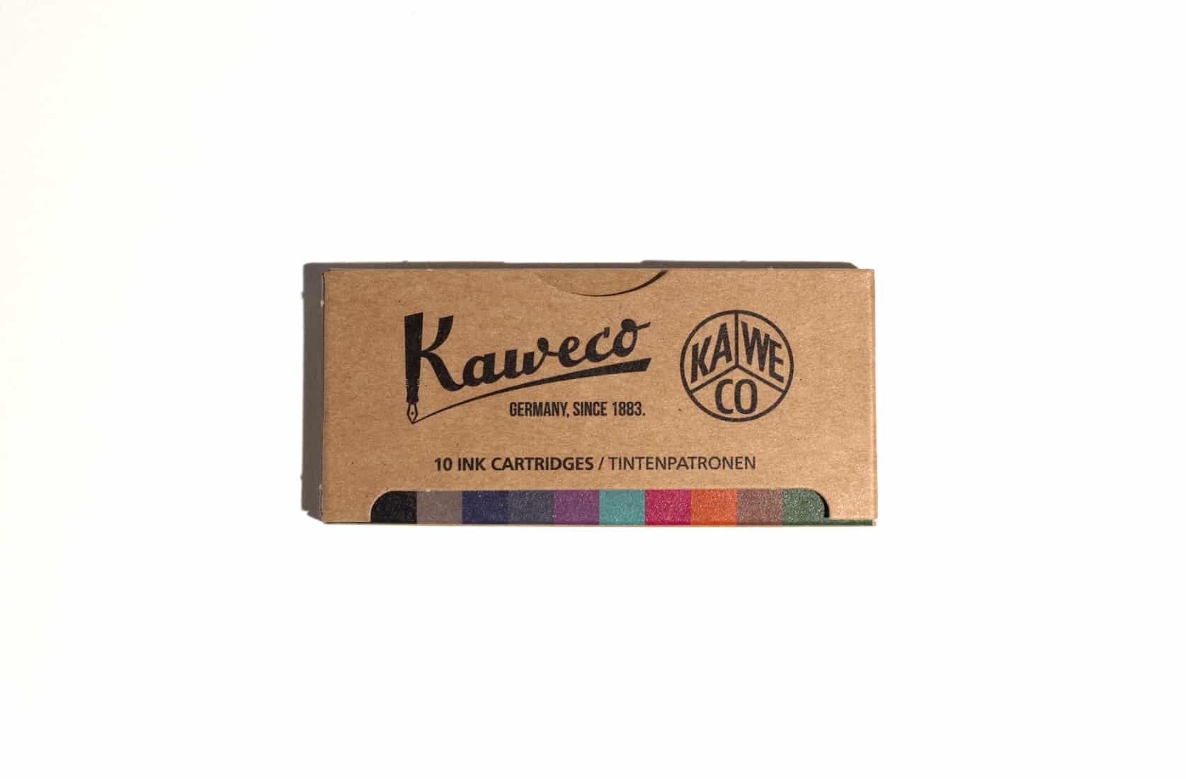 A box of ink cartridges lies on a white surface. Text on packaging reads: Kaweco. Kaweco logo. Germany, since 1883. 10 Ink Cartridges / Tintenpatronen. At the bottom of the box ten different shades of colour are visible.