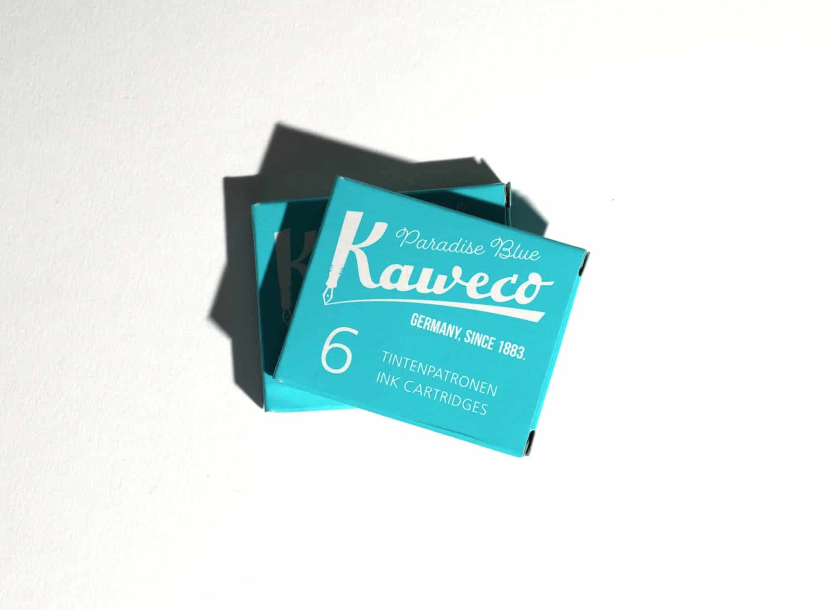 Two boxes of ink cartridges lie on a white surface. Text on packaging reads: Kaweco. Paradise Blue. Germany, since 1883. 6 Tintenpatronen. Ink Cartridges.