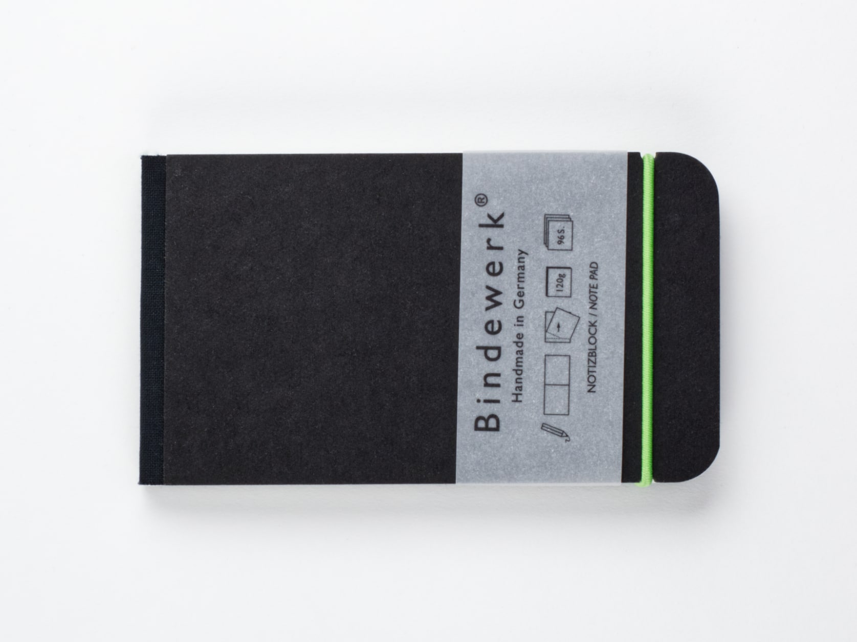 Black horizontal sketchpad with a green elastic and a sleeve with the Bindewerk logo and the words Handmade in Germany on it