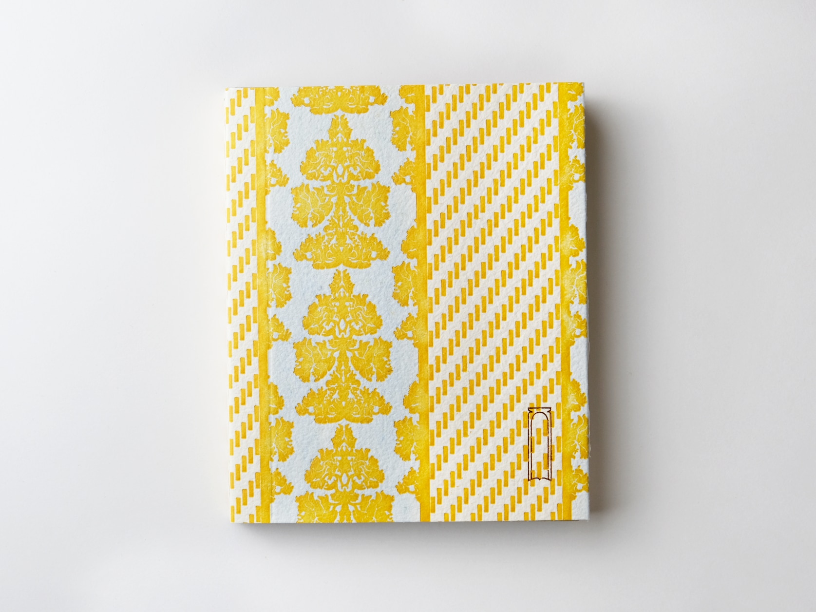 A journal with an embossed yellow pattern on a white background