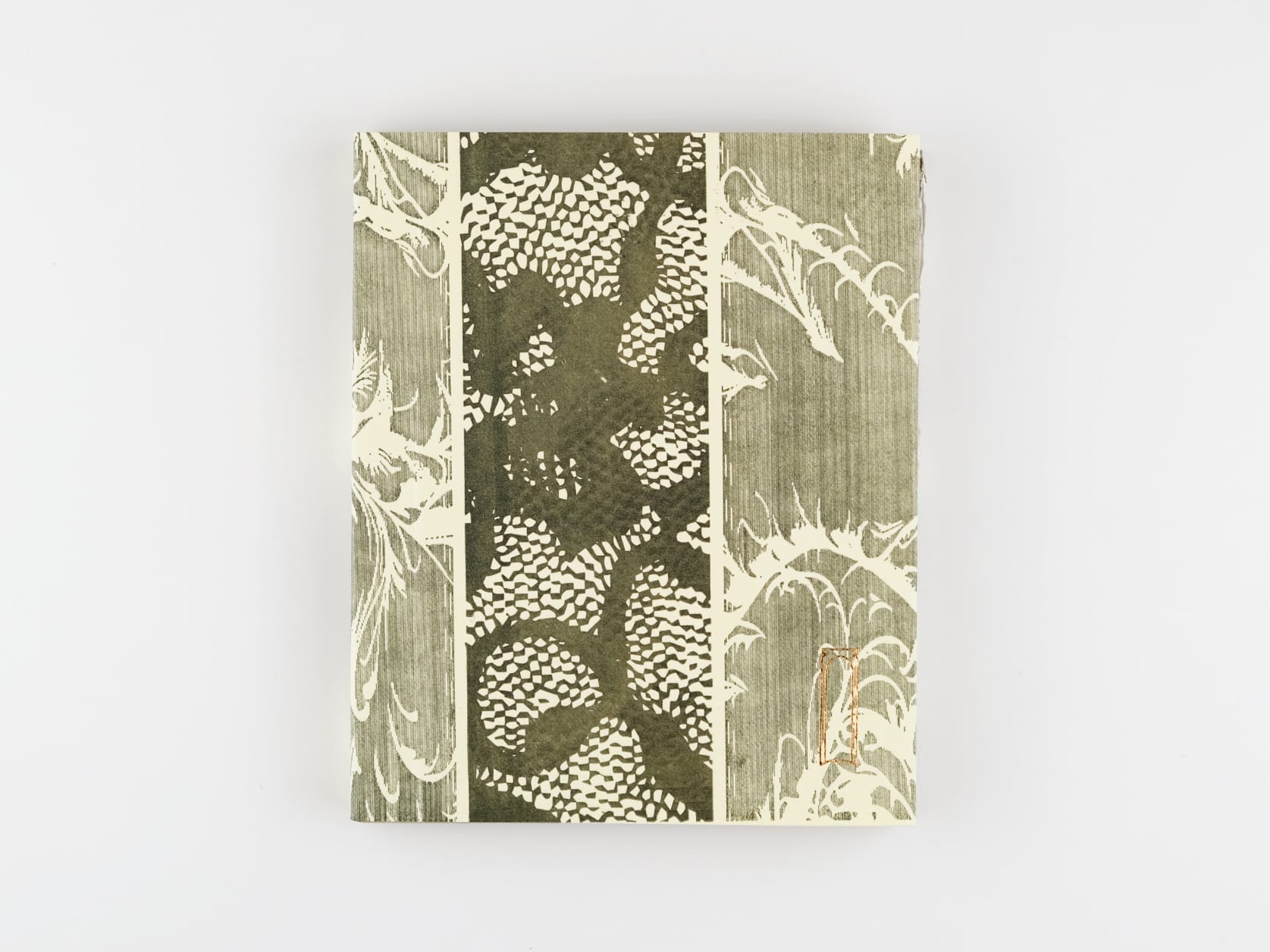 An unsaturated green journal with abstract floral patterns on the cover